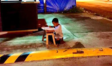 FOTO LAJM/ I pastrehë, 9-vjeçari bën detyrat në rrugë nën dritën e lokalit të McDonald