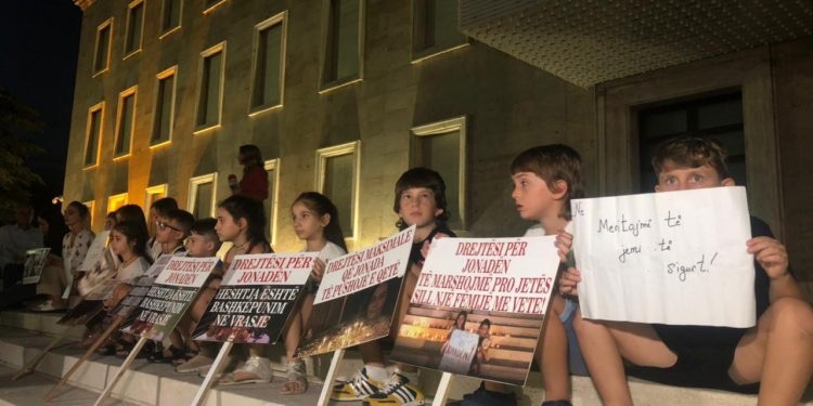 PROTESTA PËR JONADËN/ “ Kë do përqafojnë sonte prindërit e Jonadës”, fëmijët me pankarta në duar ulen në shkallët e kryeministrisë