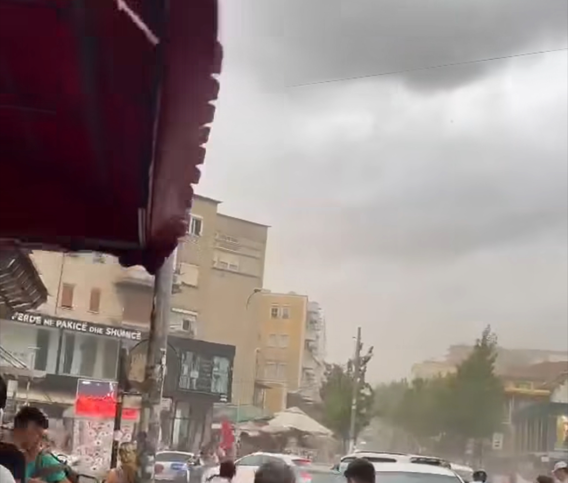 Një stuhi e papritur përfshin Tiranën, erërat e shpejta rrëzojnë pemë, pluhuri i papastruar i verës përplaset në dritaret e pallateve